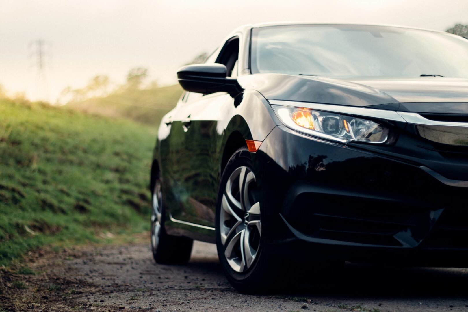 A black car is parked on the side of a road.